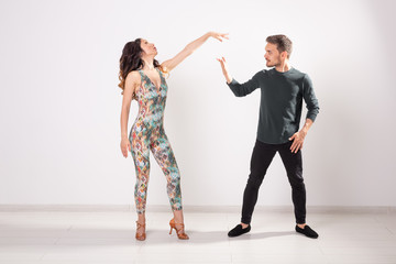 Fototapeta premium Salsa, kizomba and bachata dancers on white background with copy space. Social dance concept