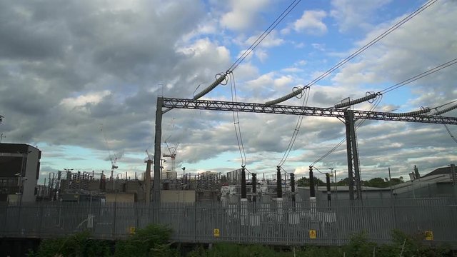 Pan right on a power station with power lines and electricity cables.