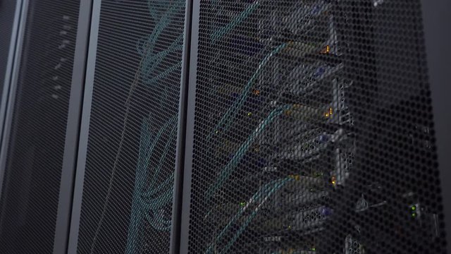 Optical server is located behind the iron door of the data center server room. View through the round vents of the cabinet wall