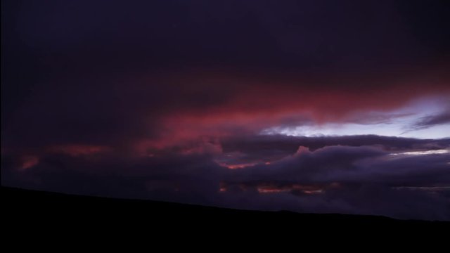 timelapse from Mauna Loa on the big island viewing Mauna Kea and red cloud formations.