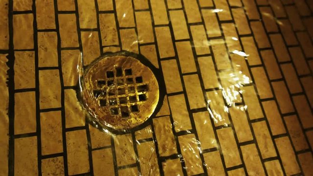 Medium shot of the drain of a fancy shower as the water drains.