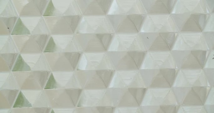 Macro shot of acrylic glass with triangular figures on it.