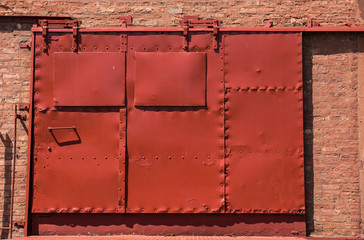 red, brown, metal paneling warehouse security delivery door.