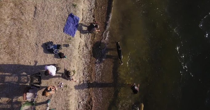 aerial drone overhead dolly in shot of Lake Cachuma, revealing family camping on the lake shore