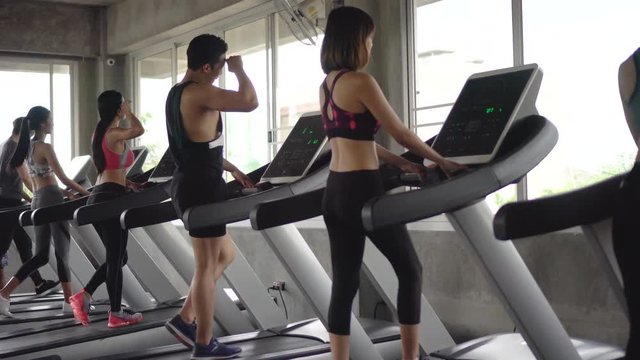 group of young people running on treadmills in sport gym .fitness woman runner on running machine . workout . man .  rear back view . training . exercise .