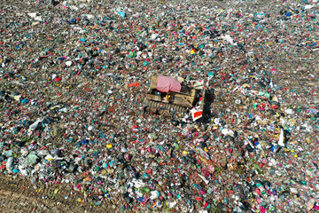 Plastic pollution crisis. Huge landfill garbage dump in Malaysia. Bulldozer flattens trash