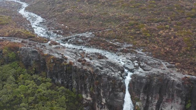 Rainy landscape of New Zealands Tongariro Crossing, Aerial pullback revealing Taranaki Falls 4k