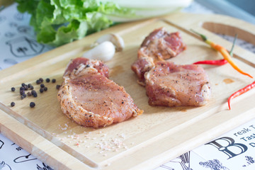 Raw pork steak on cutting board