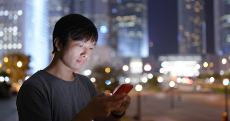Asian man use of mobile phone in city at night