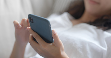 Woman use of smart phone and lying down on sofa