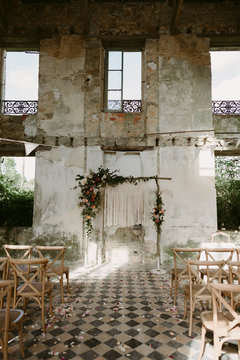 Bohemian handmade macrame backdrop with flowers for wedding ceremony in old abandoned chateau in Normandy