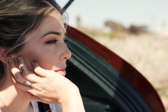 Close up of a woman sitting in the back of a car while deep in thought