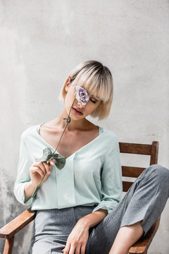 woman with a lilac flower over her eye