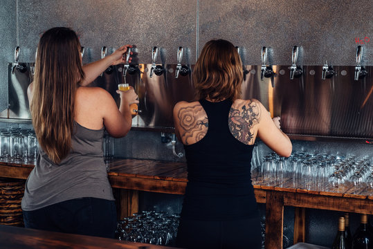 Female bartenders serving tap craft beer