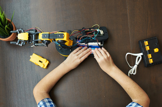 Young boy assembling a robotic arm kit