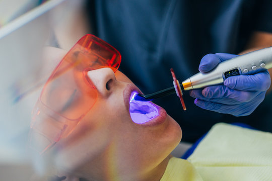 Dentist examining a patient with UV light
