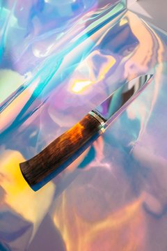 Stylish knife on colorful holographic background