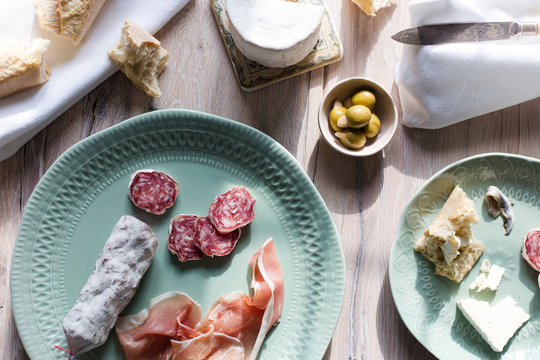 A european inspired lunch of baguette, cheese, charcuterie, olives and anchovies.