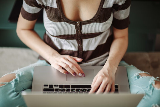 Young anonymous woman using laptop