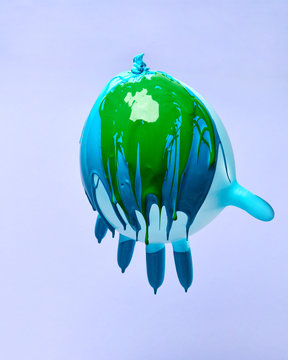 Green and blue paint drips with an inflated rubber glove