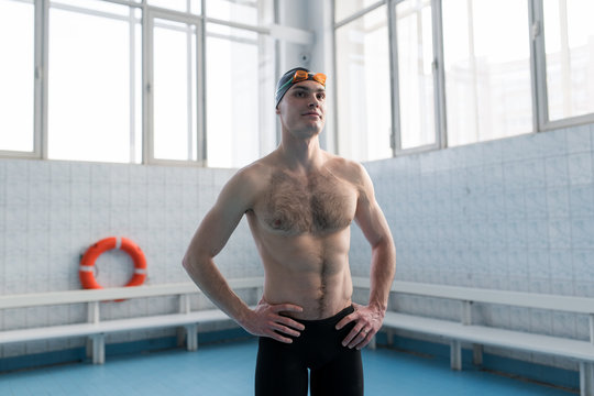 Sportive swimmer standing in pool building