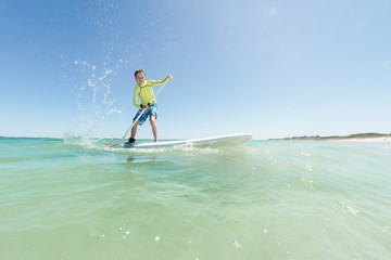 Boy on a SUP board at the beach in summer