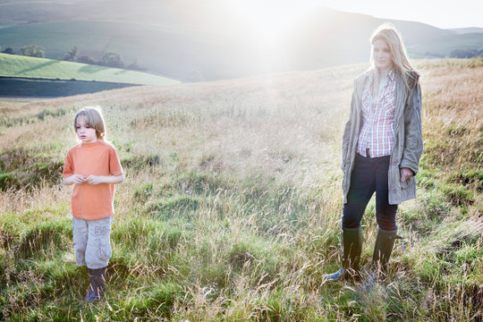 A mother and pause on a walk through a sunlit valley