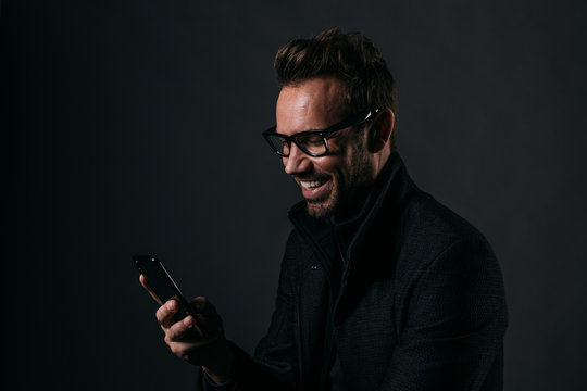 Cheerful man looking at his mobile phone