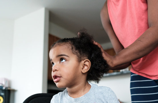 Mother doing her daughters hair