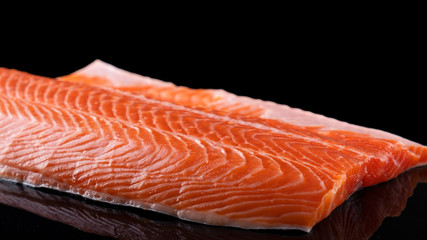 Raw salmon filet  isolated on dark  background. Uncooked salmon fillet