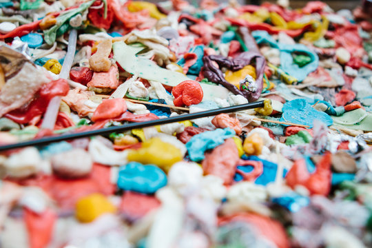 Chewed bubble gum stuck on a wall in colorful patters and colors