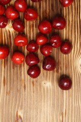 Naklejka na ściany i meble Red sweet cherry scattered on a wooden table