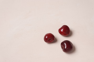 Red sweet cherry scattered on cream background