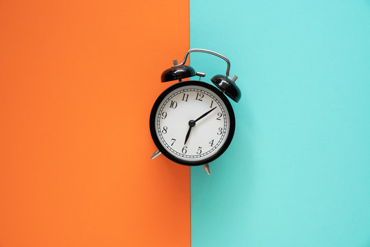 Retro alarm clock on color table background, vintage style