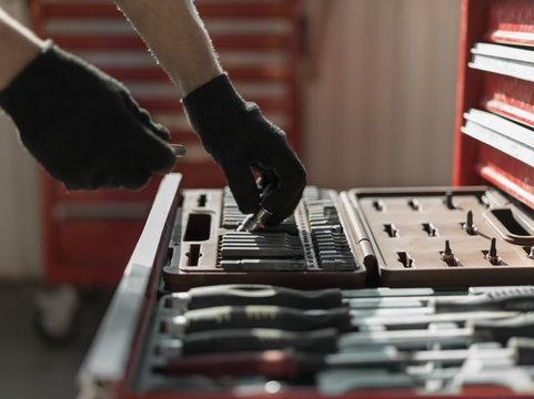 Technician taking necessary tools from kit - Powered by Adobe
