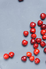Naklejka na ściany i meble Red sweet cherry scattered on a gray background
