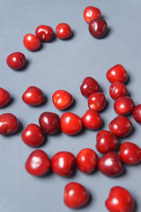 Red sweet cherry scattered on a gray background