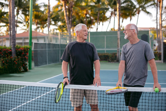 Middle Age Men Talking At Tennis Net
