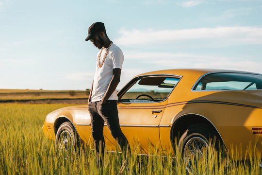 Black african man besides a classic car waiting for assistance