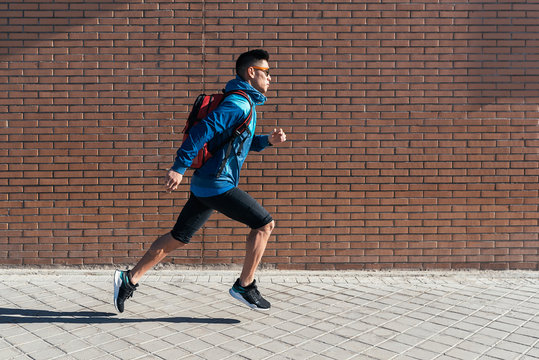 Handsome asian man running in the city.