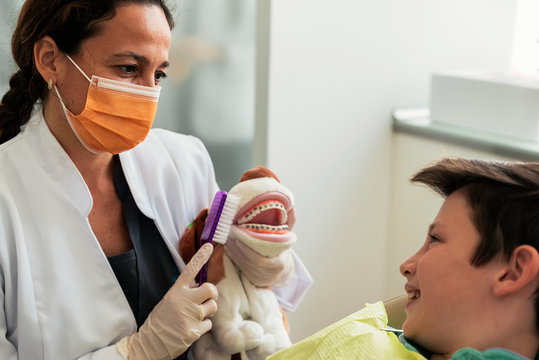 Doctor dentist teaching a child to brush teeth.