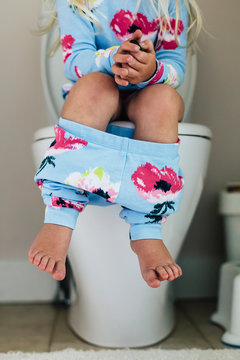 Child Seated on Toilet