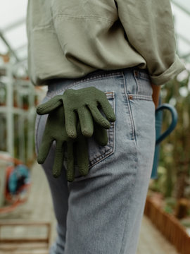 Crop woman with gloves in jeans pockets