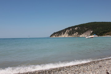Beach, a pebble beach and a boat on the water.