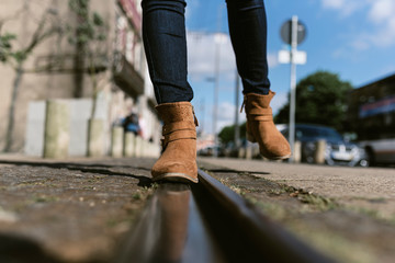 Crop female legs walking on street