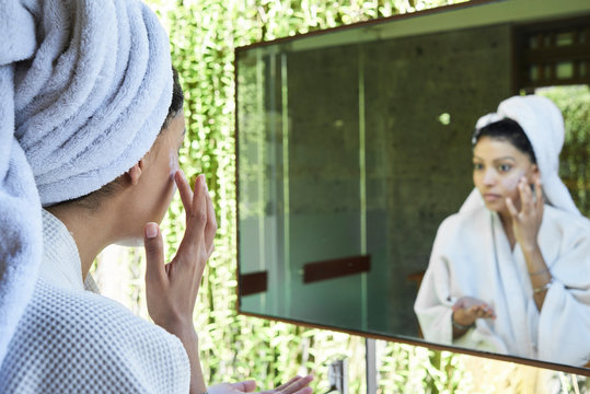 Girl taking beauty care in bathroom.