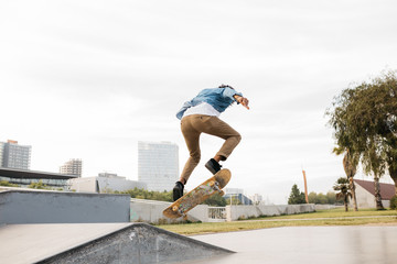 Active hipster jumping on skateboard