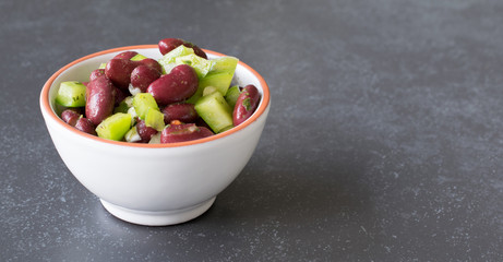 A fresh kidney bean and green pepper salad in a small white bowl with copy space for your text