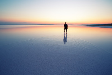 Salt lake Tuz with man leaving at sunset