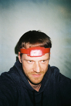Young funny man with beard and red headlamp